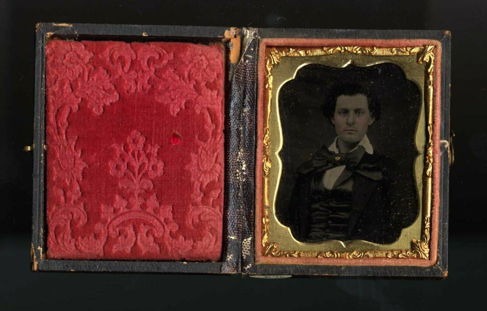 Ambrotype of young man with flamboyant bow tie with gold pin. Nice coloring.